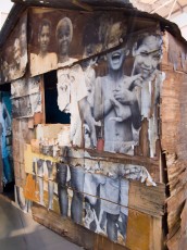 Installation de JR au Pavillon de l'Arsenal à Paris dans le cadre de son projet "Women are Heroes". JR a fait installer une maison qu'il a démonté d'une favela de Rio et sur laquelle il avait fait le collage de tous les membres de la famille qui y vivait. La maison démontée a été remplacée dans la favéla par une maison en dur - Octobre 2009